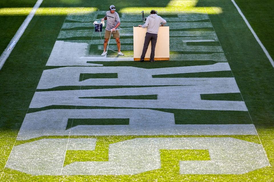 Michigan State University Assistant Sports Turf Manager Brian McDougal, left, and student assistant Nate Booth paint the end zone ahead of the opening football game on Thursday, Aug. 31, 2023, at Spartan Stadium in East Lansing.