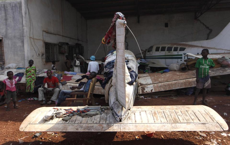 A displaced family take shelter under a plane in Bangui