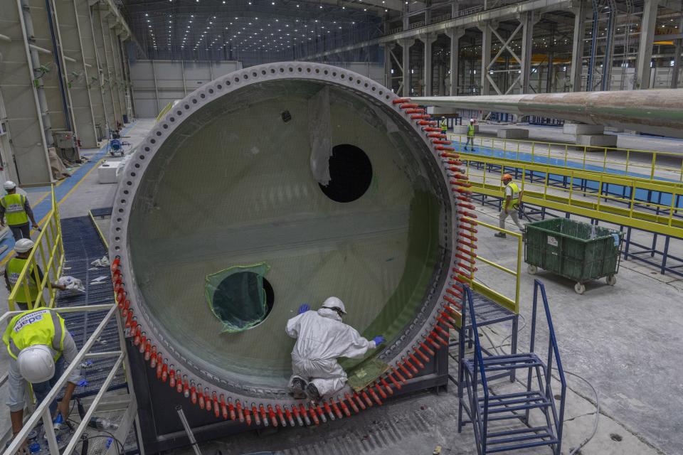 Employees work on a wind turbine blade at the Adani New Industries Limited in the port town of Mundra in Western India's Gujarat state, India, Wednesday, Sept. 20, 2023. It's one of the few locations in India where most solar energy components are made from scratch. (AP Photo/Rafiq Maqbool)