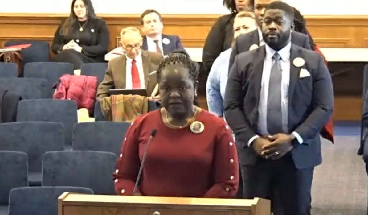 Caroline Ouko, mother of Irvo Otieno, testifies before a House Courts of Justice subcommittee Monday, Jan. 29, 2024, at the General Assembly Building in Richmond. She spoke in support of 'Irvo's Law,' legislation that would allow family members access to loved ones amid mental crisis receiving emergency medical treatment. Behind her is her son. Leon Ochieng.