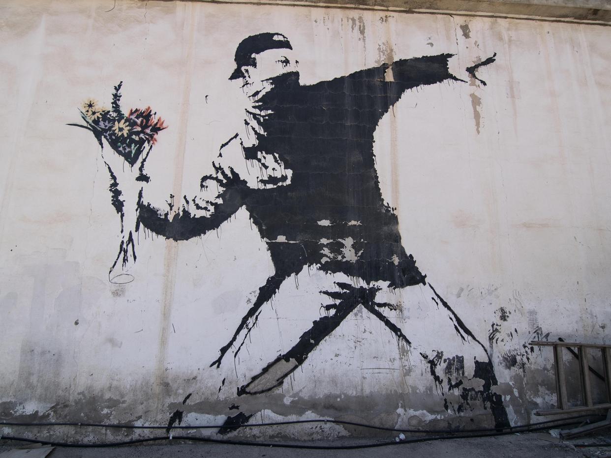 Banksy's graffiti mural 'The Flower Thrower', which was painted on a Jerusalem wall in 2005 (Alamy Stock Photo)