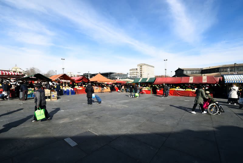 People walk through Porta Palazzo market, as a coronavirus outbreak continues to grow in northern Italy, in Turin