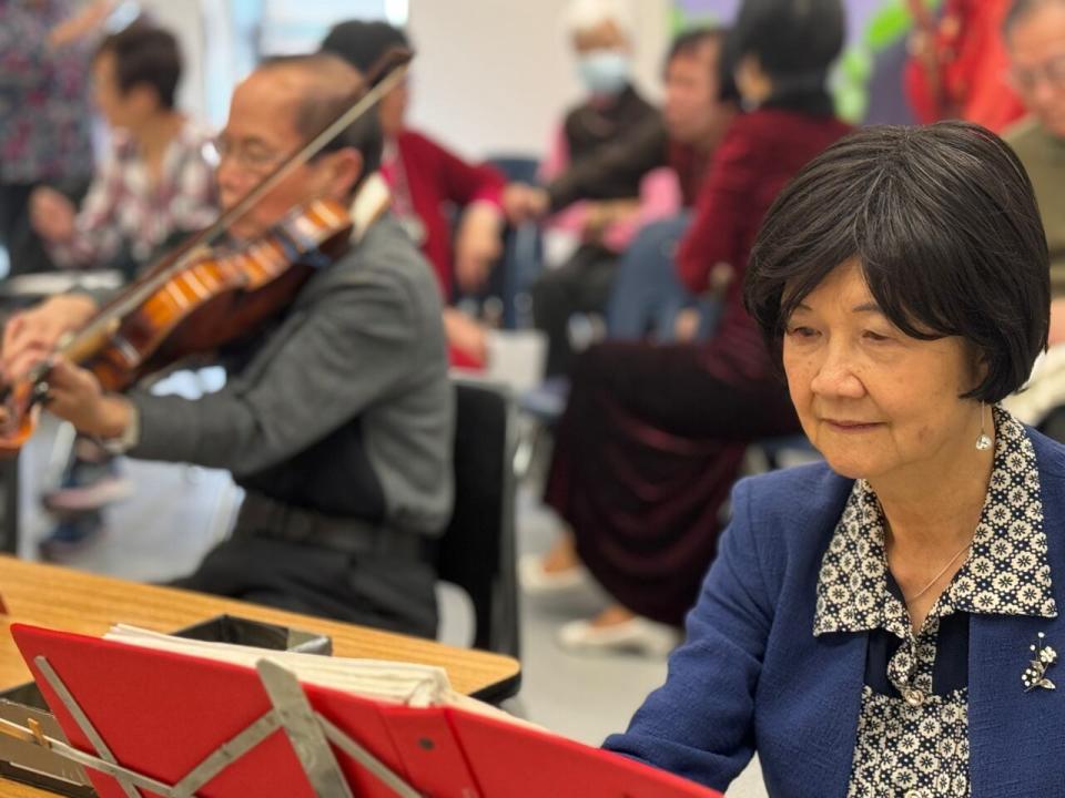 Jenny Lee follows musicians as the Regina Chinese Musical Association practice on a Monday afternoon. Her husband, David Ling, accompanies the performers. 