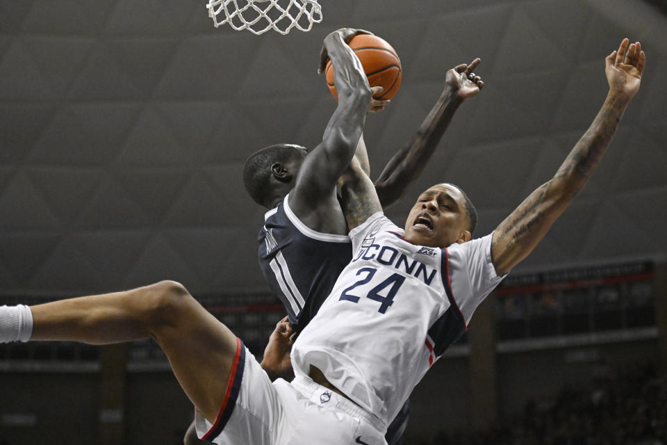 Georgetown's Akok Akok, blocks a shot attempt by Connecticut's Jordan Hawkins in the first half of an NCAA college basketball game, Tuesday, Dec. 20, 2022, in Storrs, Conn. (AP Photo/Jessica Hill)