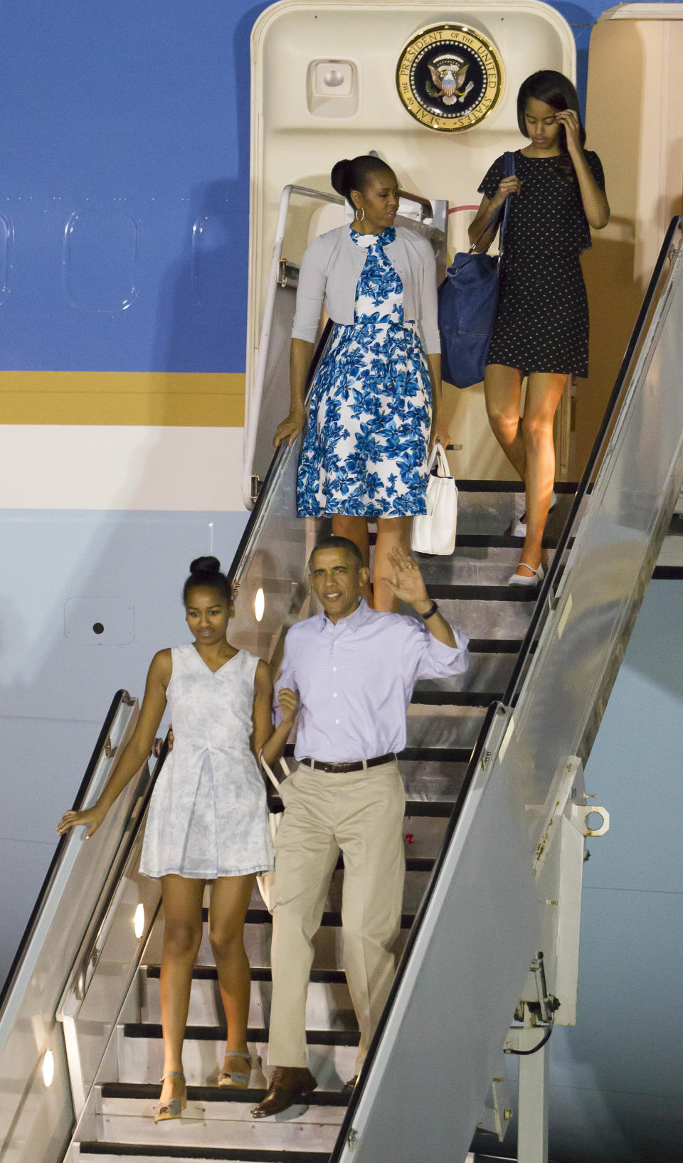 President Barack Obama, his daughter Sasha, the first lady Michelle Obama and their other daughter Malia disembark Air Force One after arriving at Joint Base Pearl Harbor-Hickam for their annual family Christmas vacation Friday, Dec. 19, 2014, in Honolulu.