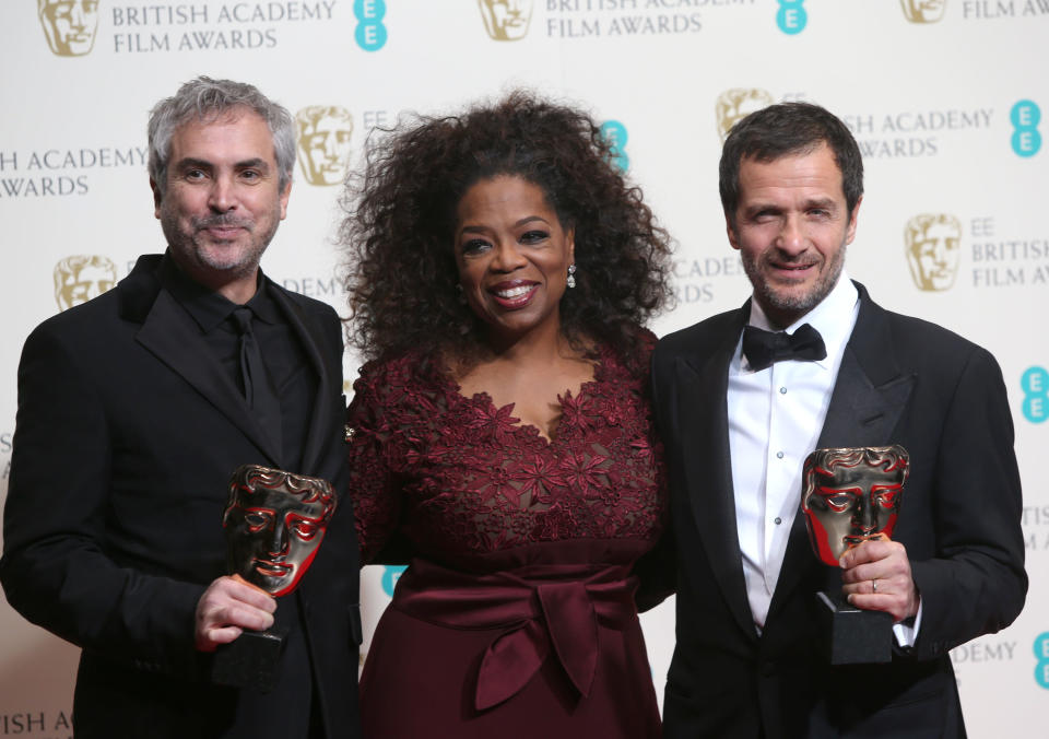 From left, Alfonso Cuaron, Oprah Winfrey and David Heyman, winners of outstanding British film for Gravity, pose for photographers in the winners room at the EE British Academy Film Awards held at the Royal Opera House on Sunday Feb. 16, 2014, in London. (Photo by Joel Ryan/Invision/AP)