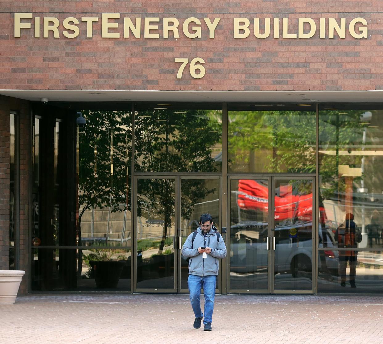 An employee leaves work Wednesday at the FirstEnergy Building in Akron. The company has announced it is leaving downtown and relocating its corporate headquarters to West Akron.