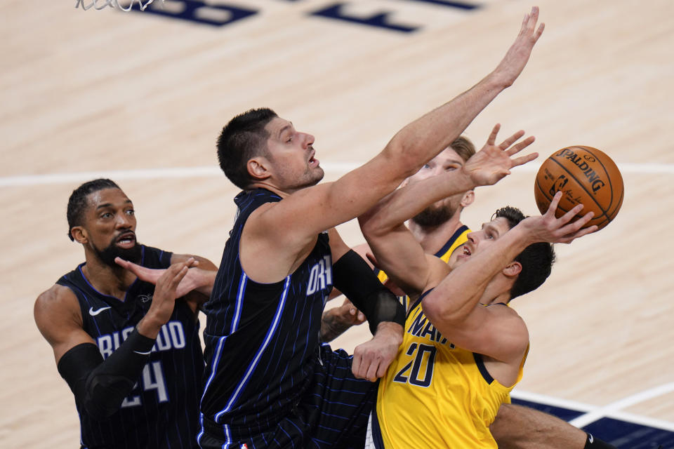 Indiana Pacers forward Doug McDermott, right, shoots as Orlando Magic center Nikola Vucevic (9) defends during the second half of an NBA basketball game in Indianapolis, Friday, Jan. 22, 2021. (AP Photo/AJ Mast)