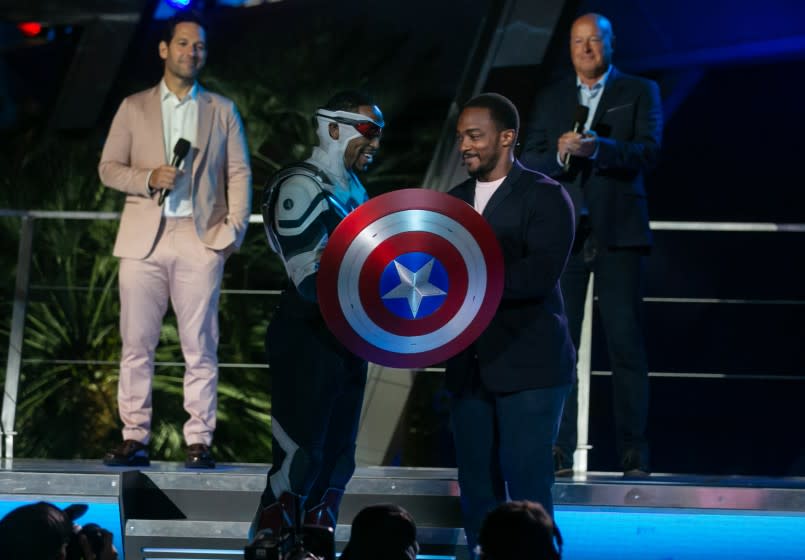 ANAHEIM, CA - JUNE 02: Actor Anthony Mackie, the first Black Captain America, presents California Adventure's Black Captain America, with his shield during the grand opening ceremony of Disney California Adventure's new Avengers Campus on Wednesday, June 2, 2021 in Anaheim, CA. (Jason Armond / Los Angeles Times)