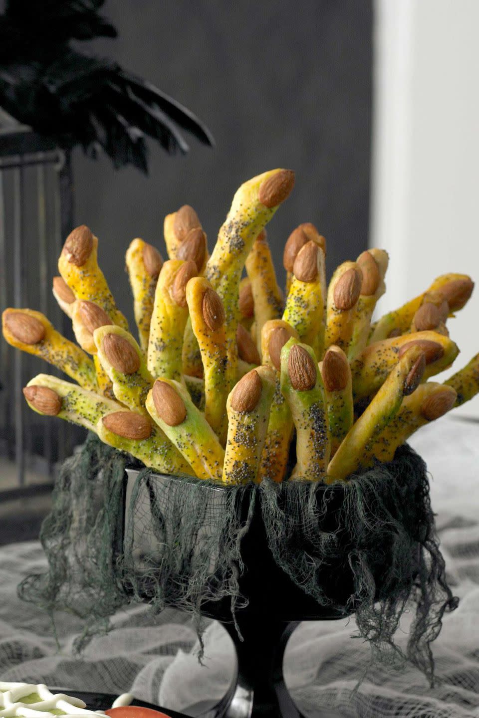 <p>Shape ready-made breadstick dough into fingers, tint with spray color, then top with an almond "fingernail" and poppyseeds.</p><p><strong><a rel="nofollow noopener" href="https://www.womansday.com/food-recipes/food-drinks/recipes/a10110/long-short-monster-fingers-recipe-121385/" target="_blank" data-ylk="slk:Get the recipe;elm:context_link;itc:0;sec:content-canvas" class="link ">Get the recipe</a>.</strong></p><p><strong>Tools you'll need: </strong>food color sprays, $16; <a rel="nofollow noopener" href="https://www.amazon.com/Wilton-Halloween-Color-Mist-Spray/dp/B0046CKTPE" target="_blank" data-ylk="slk:amazon.com;elm:context_link;itc:0;sec:content-canvas" class="link ">amazon.com</a>.<strong><br></strong></p>