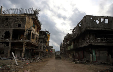 A military truck drives past damaged buildings after government troops cleared the area from pro-Islamic State militant groups inside a war-torn area in Bangolo town, Marawi City, southern Philippines October 23, 2017. REUTERS/Romeo Ranoco