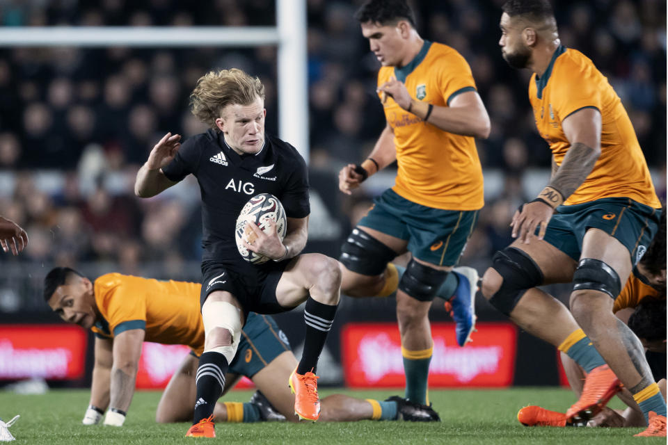 New Zealand's Damian McKenzie, second left, looks for a gap in the Australian defense during their Bledisloe Cup rugby union test match at Eden Park in Auckland, New Zealand, Saturday, Aug. 7, 2021. (Brett Phibbs/Photosport via AP)