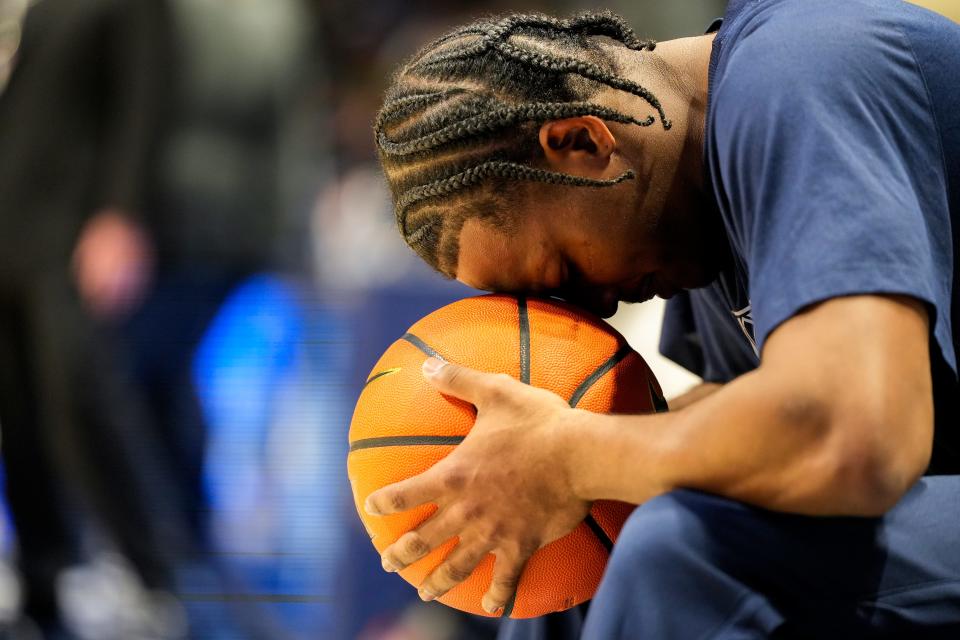 Xavier Musketeers guard Quincy Olivari (8) puts his head to the ball in pre-game ritual in the first half of the NCAA basketball game between the Winthrop Eagles and Xavier Musketeers on Saturday, Dec. 16, 2023, at the Cintas Center in Cincinnati.