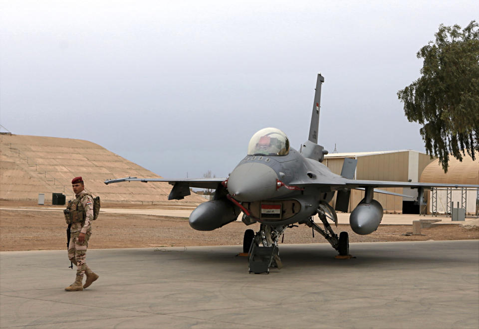 FILE - In this Feb. 13, 2018 file photo, an Iraqi army soldier stands guard near a U.S.-made Iraqi Air Force F-16 fighter jet at the Balad Air Base, Iraq. The Iraqi government has told its military not to seek assistance from the U.S.-led coalition forces in operations against the Islamic State group, two senior Iraqi military officials said. The move comes amid a crisis of mistrust tainting U.S.-Iraq ties after an American strike killed a top Iranian general and Iraqi militia commander. (AP Photo/Khalid Mohammed, File)