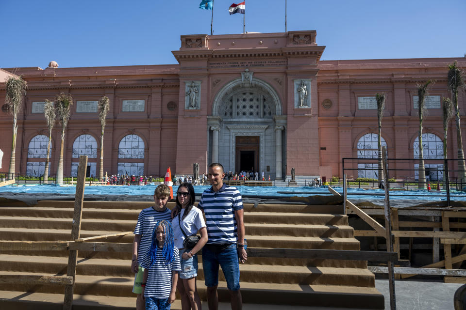 Una familia posa para una fotografía delante del Museo Egipcio de El Cairo, el miércoles 10 de mayo de 2023. En la entrada del museo, hay estatuas de Cleopatra. (Heba Khamis/The New York Times)