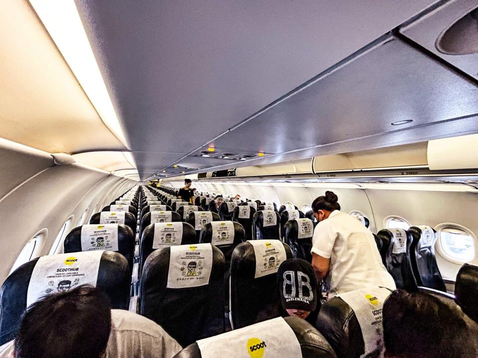 A photo inside a Scoot plane, showing rows of empty seats.