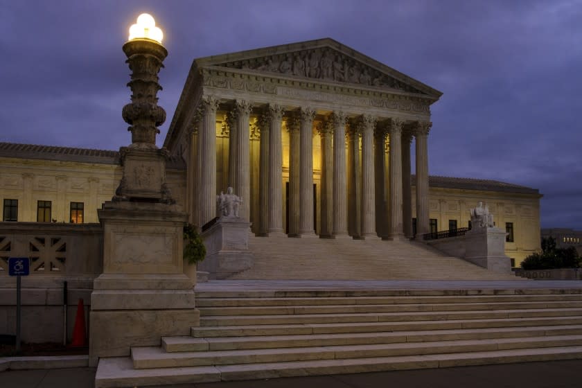 In this Oct. 5, 2018 photo the U. S. Supreme Court building stands quietly before dawn in Washington. The Supreme Court won't let the Trump administration begin enforcing a ban on asylum for any immigrants who illegally cross the U.S.-Mexico border. New Justice Brett Kavanaugh and three other conservative justices sided with the administration. The court's order Friday leaves in place lower court rulings that blocked President Donald Trump's proclamation in November automatically denying asylum to people who enter the country from Mexico without going through official border crossings. (AP Photo/J. David Ake)