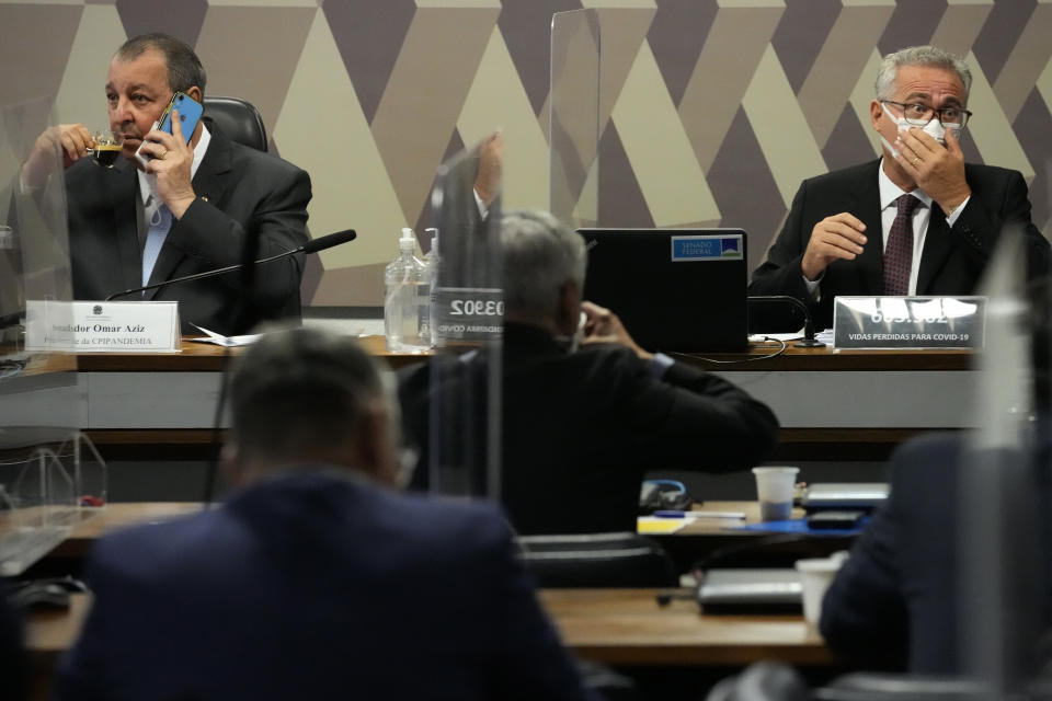 Senators Omar Aziz, left, and Renan Calheiros, attend a session by their commission investigating the government's management of the COVID-19 pandemic at the Federal Senate in Brasilia, Brazil, Wednesday, Oct. 20, 2021. Calheiros formally presented his report recommending President Jair Bolsonaro be indicted on criminal charges for allegedly bungling Brazil's response to pandemic and pushing the country's death toll to second-highest in the world. (AP Photo/Eraldo Peres)