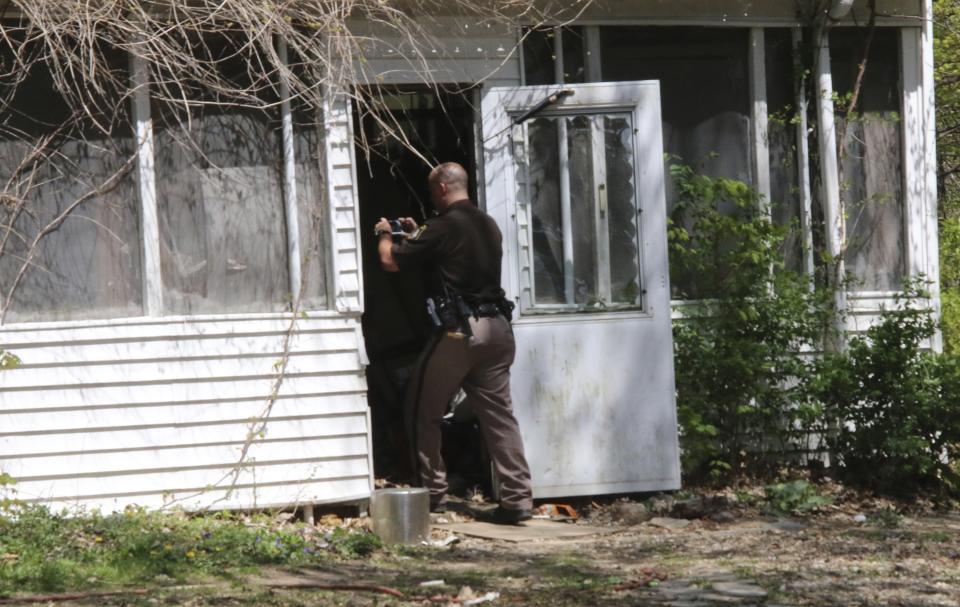 In this Monday, May 6, 2019 photo, a St. Joseph County Sheriff deputy photographs the site where a woman was fatally shot in Fawn River Township, Mich. Authorities say a 9-year-old is suspected in the shooting of a woman in her southern Michigan home. (Corky Emrick/Sturgis Journal via AP)