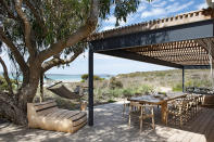 <p>A l’ombre d’un acacia, le hamac et le daybed (Weylandts) invitent au farniente. Tout est pensé pour vivre en harmonie avec la nature dans le respect de l’environnement et des valeurs écologiques. Sous la pergola, la terrasse en garapa laisse découvrir un panorama unique sur la lagune. Table en chêne de James Mudge, chaises « Horn » en teck et corde tressée ( <a href="https://www.weylandts.co.za/" rel="nofollow noopener" target="_blank" data-ylk="slk:Weylandts;elm:context_link;itc:0;sec:content-canvas" class="link ">Weylandts</a>) et vaisselle ( <a href="https://wonkiware.com/" rel="nofollow noopener" target="_blank" data-ylk="slk:Wonki Ware;elm:context_link;itc:0;sec:content-canvas" class="link ">Wonki Ware</a>).</p><br>