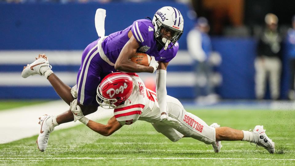 Ben Davis Giants Mark Zackery (4) is tackled by Crown Point Bulldogs Jacob Jones (5) on Saturday, Nov. 25, 2023, during the IHSAA Class 6A football state championship game at Lucas Oil Stadium in Indianapolis. The Ben Davis Giants lead at the half against the Crown Point Bulldogs, 10-3.