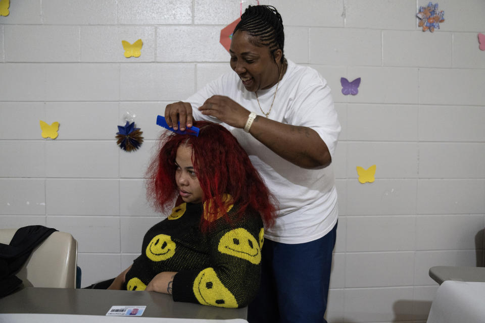Latonya Dextra braids the hair of her 27-year-old daughter Nyia Pritchett during a special visit at Logan Correctional Center, Saturday, May 20, 2023, in Lincoln, Illinois. Pritchett hadn't seen her mother for three years. Rare programs like the Reunification Ride, a donation-dependent initiative that buses prisoners' family members from Chicago to Illinois' largest women's prison every month so they can spend time with their mothers and grandmothers, are a crucial lifeline for families, prisoners say. (AP Photo/Erin Hooley)
