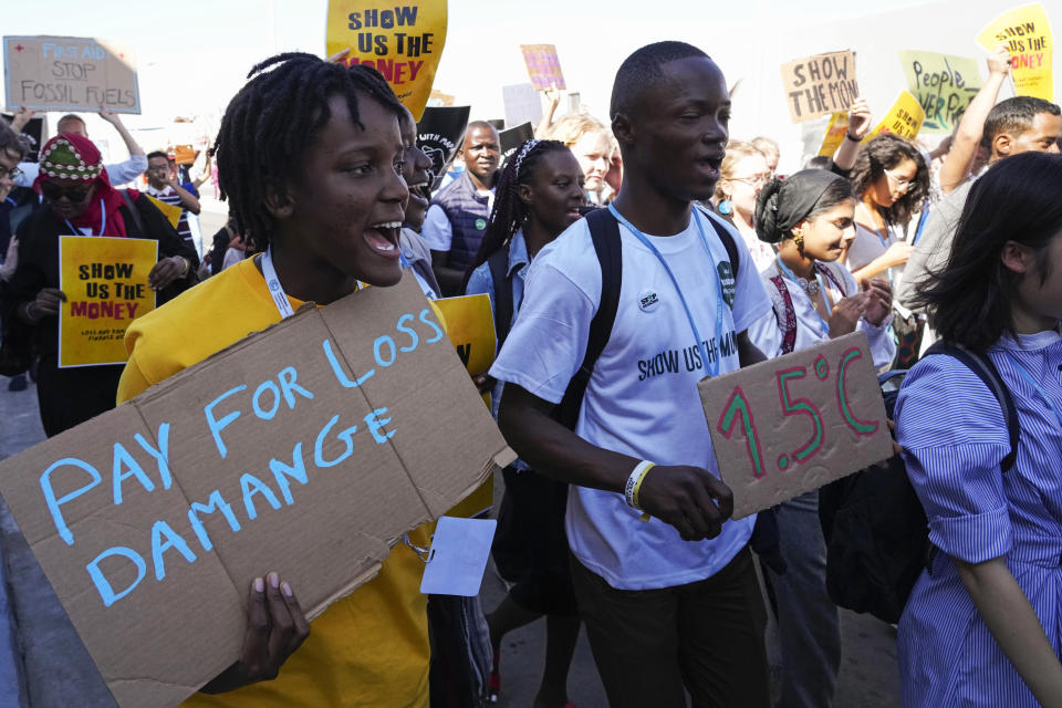 Vanessa Nakate, of Uganda, left, participates in a Fridays for Future protest at the COP27 U.N. Climate Summit while holding a sign that says "pay for loss and damage", Friday, Nov. 11, 2022, in Sharm el-Sheikh, Egypt. (AP Photo/Peter Dejong)