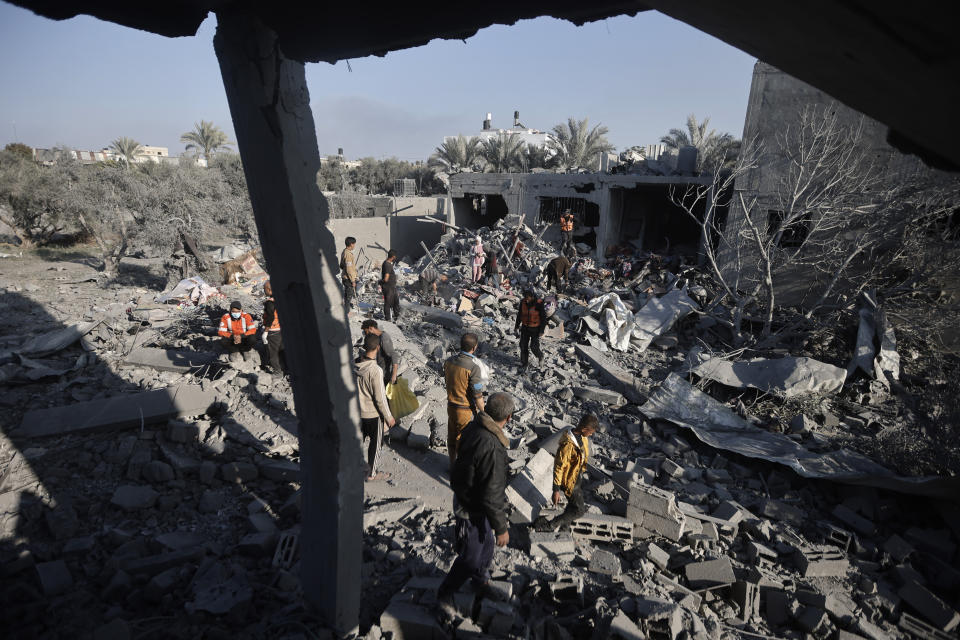 Palestinians inspect the damage of a destroyed house following Israeli airstrikes on Khan Younis, Southern Gaza Strip, Sunday, Dec. 31, 2023. (AP Photo/Mohammed Dahman)