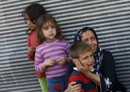 A mother and her children react after two rockets hit the Turkish town of Kilis near the Syrian border, Turkey, April 24, 2016. REUTERS/Umit Bektas