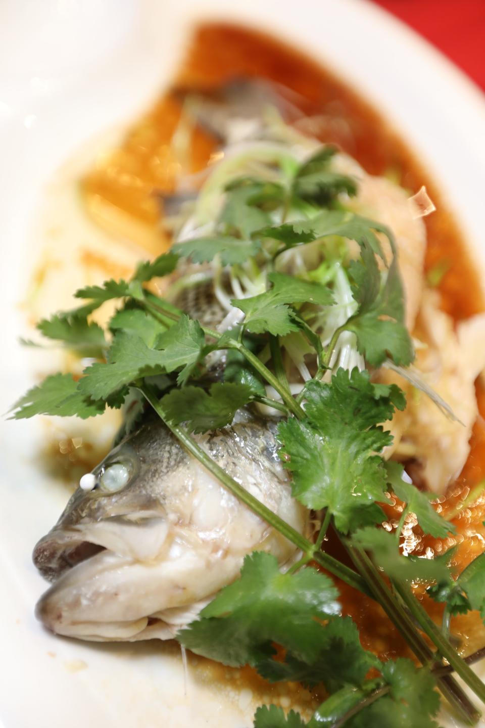 Steamed sea bass in soy sauce with ginger and scallions.