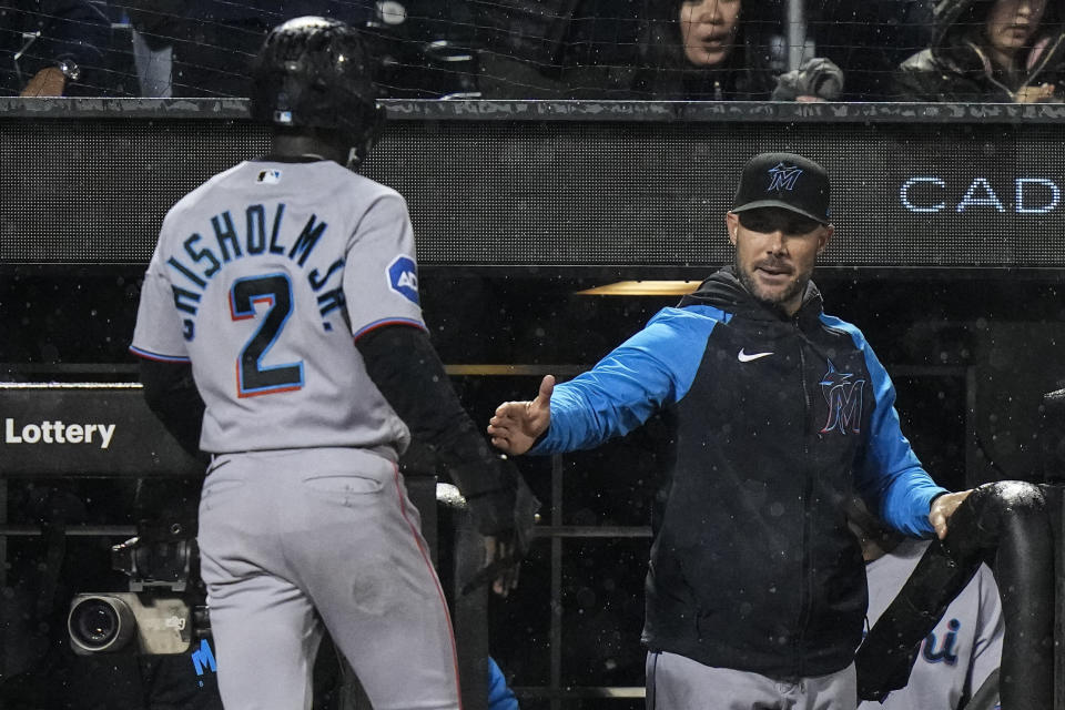 Miami Marlins manager Skip Schumaker, right, shakes hands with Jazz Chisholm Jr., who scored on a single by Yuli Gurriel during the ninth inning of the team's baseball game against the New York Mets on Thursday, Sept. 28, 2023, in New York. (AP Photo/Frank Franklin II)