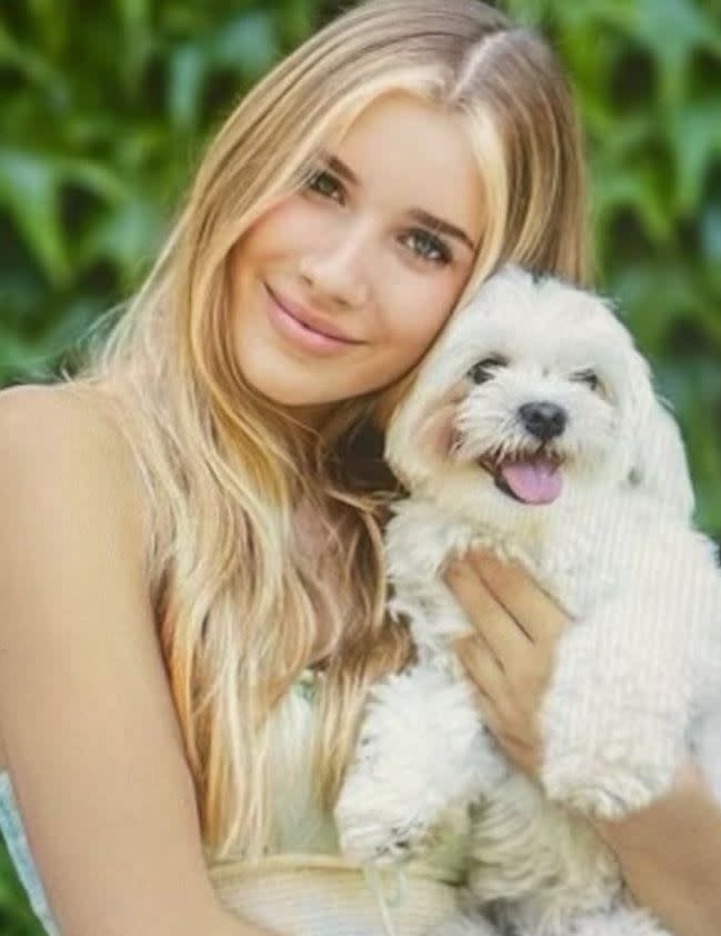 A teenage girl holding a white dog