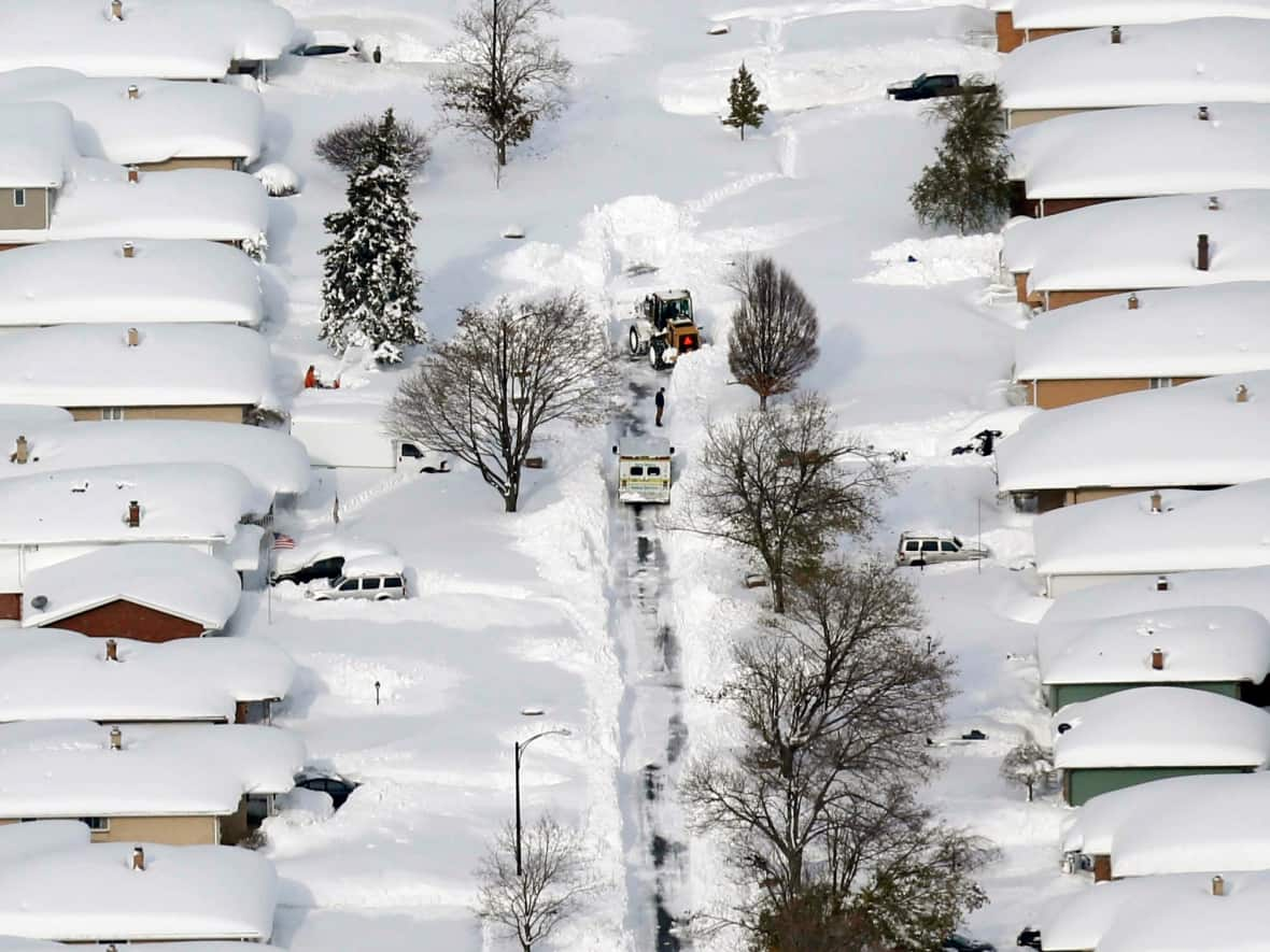 A bulldozer clears the way in West Seneca, N.Y., just outside Buffalo, on Nov. 19, 2014. The area could get up to 1.2 metres of snow this weekend. (Derek Gee/The Buffalo News/The Associated Press - image credit)