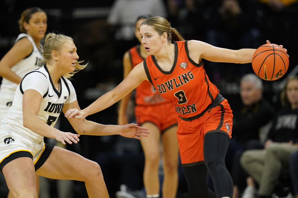 Bowling Green guard Morgan Sharps (0) drives past Iowa guard Sydney Affolter (3) during the first half of an NCAA college basketball game, Saturday, Dec. 2, 2023, in Iowa City, Iowa. (AP Photo/Charlie Neibergall)