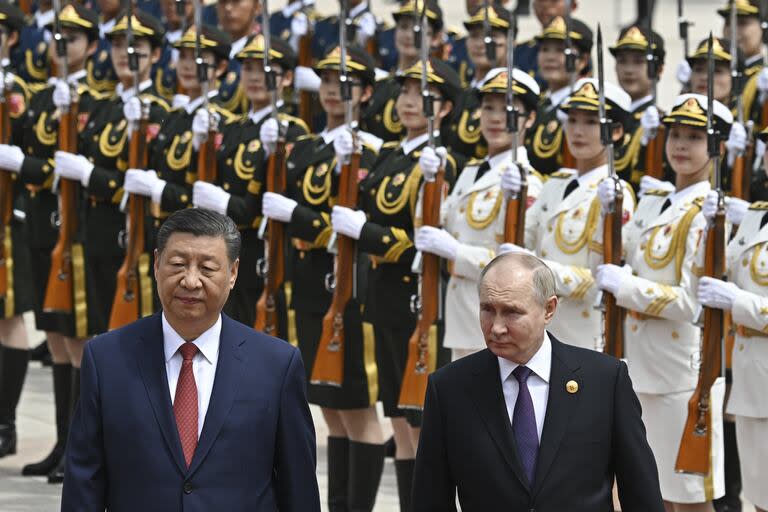 El presidente chino Xi Jinping (izquierda) y el presidente ruso Vladimir Putin pasan revista a la guardia de honor durante una ceremonia oficial de bienvenida en Pekín