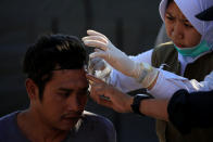 <p>A paramedic treats an injured man outside of Tanjung hospital, after an earthquake hit in Lombok Utara, Indonesia, Aug. 6, 2018. (Photo: Beawiharta/Reuters) </p>