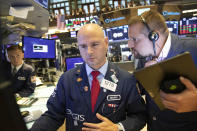 Mario Picone, center, and Michael Milano, right, work at the New York Stock Exchange, Monday, Sept. 16, 2019. Global stock markets sank Monday after crude prices surged following an attack on Saudi Arabia's biggest oil processing facility. (AP Photo/Mark Lennihan)