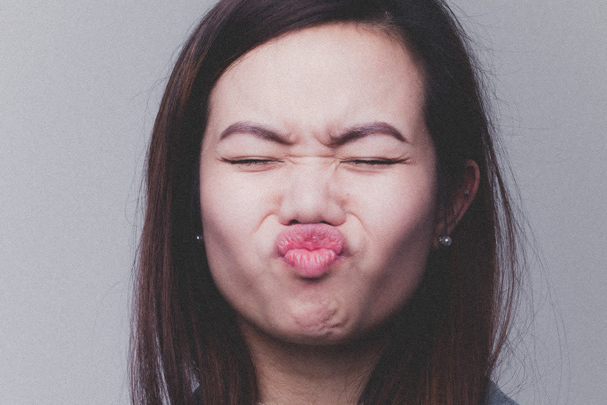 Woman with puckered lips, seemingly unhappy with something