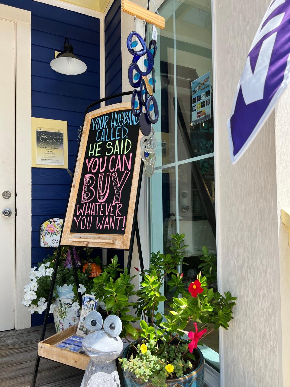 On July 28, a sign beckons shoppers into Cattail Cottage, a home decor shop located in downtown Southport.