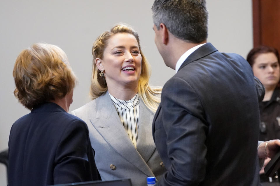 Actor Amber Heard talks with her legal team including Elaine Bredehoft, left, and Benjamin Rottenborn, right, in the courtroom at the Fairfax County Circuit Courthouse in Fairfax, Va., Friday, May 27, 2022. Actor Johnny Depp sued his ex-wife Amber Heard for libel in Fairfax County Circuit Court after she wrote an op-ed piece in The Washington Post in 2018 referring to herself as a "public figure representing domestic abuse." (AP Photo/Steve Helber, Pool)