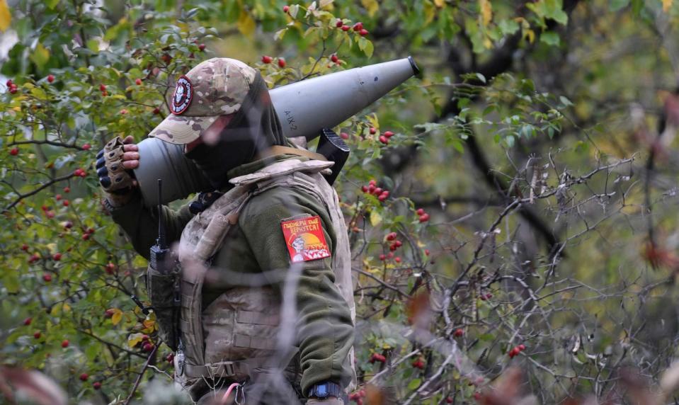 PHOTO: A serviceman of Russian private military company Wagner Group carries an artillery shell during the execution of a combat mission in the course of Russia's military operation in Ukraine, in the Luhansk People's Republic, July 10, 2022. (Viktor Antonyuk/Sputnik via AP)
