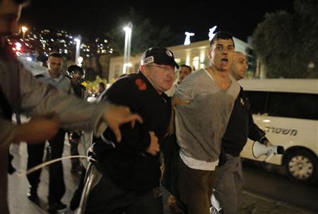 Israeli police detain a protester during a demonstration showing solidarity with Bedouin Arabs who are against a government displacement plan for Bedouins in the Southern Negev desert in the northern city of Haifa November 30, 2013. REUTERS/Ammar Awad