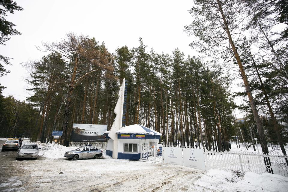 Police cars are parked at an entrance of the sanatorium in Bogandinsky in the Tyumen region, about 2150 kilometers (1344 miles) east of Moscow, western Siberia, Russia, Wednesday, Feb. 5, 2020, where virus outbreak evacuees will be quarantined for 14 days. Russia has evacuated 144 people, Russians and nationals of Belarus, Ukraine and Armenia, from the epicenter of the coronavirus outbreak in Wuhan, China, on Wednesday. All evacuees will be quarantined for two weeks in a sanatorium in the Tyumen region in western Siberia, government officials said. (AP Photo/Maxim Slutsky)