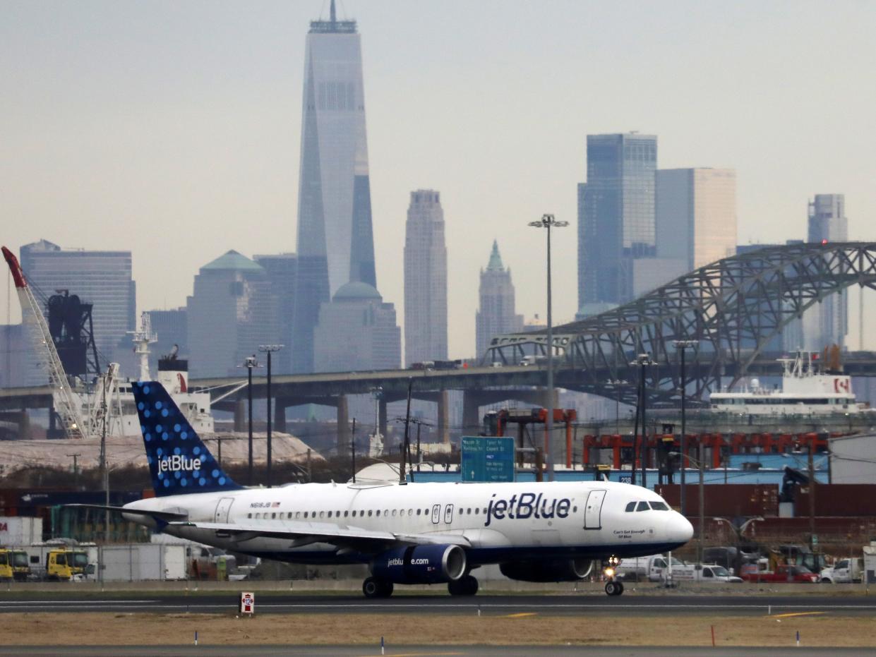 FILE PHOTO: A JetBlue passenger jet lands with New York City as a backdrop, at Newark Liberty International Airport, New Jersey, U.S. December 6, 2019. REUTERS/Chris Helgren