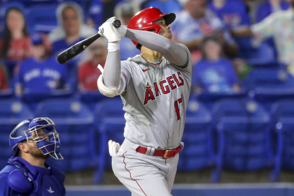 Los Angeles Angels' Shohei Ohtani watches his solo home run in front of Toronto Blue Jays catcher Alejandro Kirk during the fifth inning of a baseball game Friday, April 9, 2021, in Dunedin, Fla. (AP Photo/Mike Carlson)