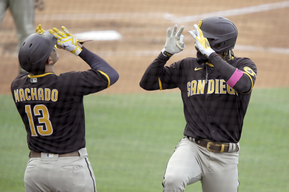 San Diego Padres' Fernando Tatis Jr., right, celebrates his solo home run with Manny Machado during the fourth inning of a baseball game against the Los Angeles Dodgers in Los Angeles, Sunday, April 25, 2021. (AP Photo/Alex Gallardo)