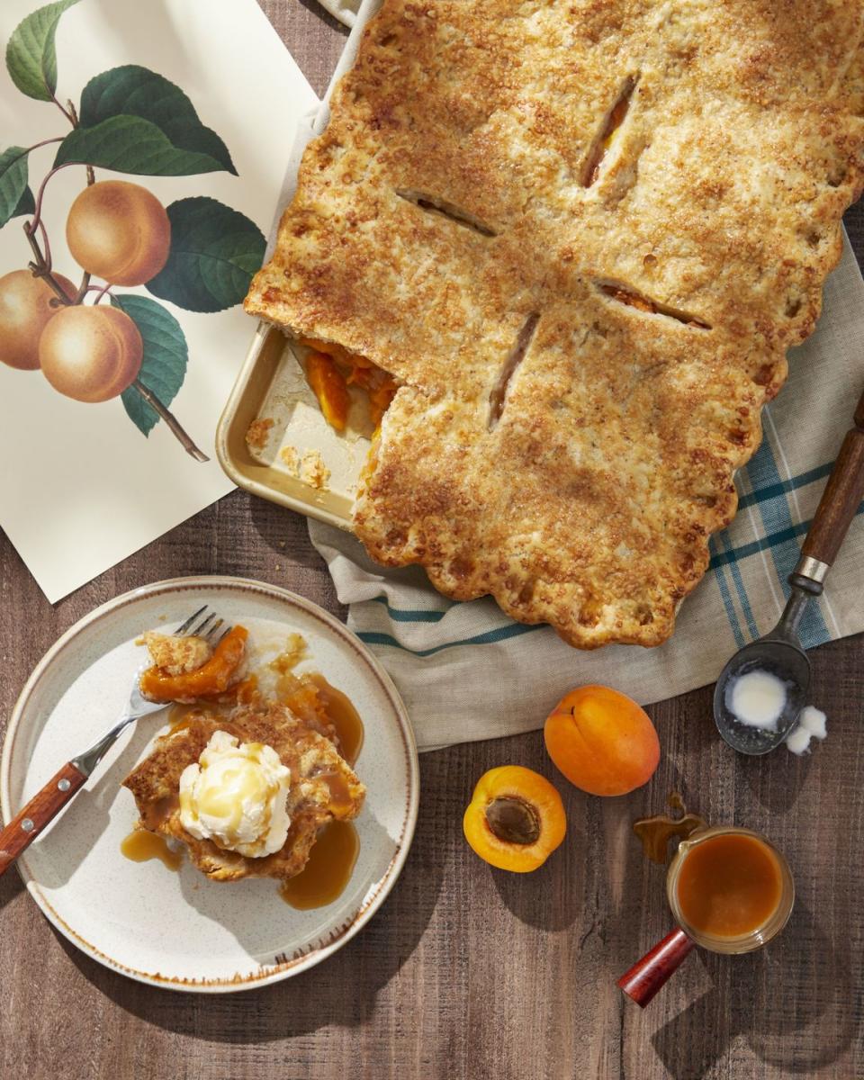 apricot almond slab pie with brandy caramel sauce in a rectangle pan with a corner piece on a plate with a fork