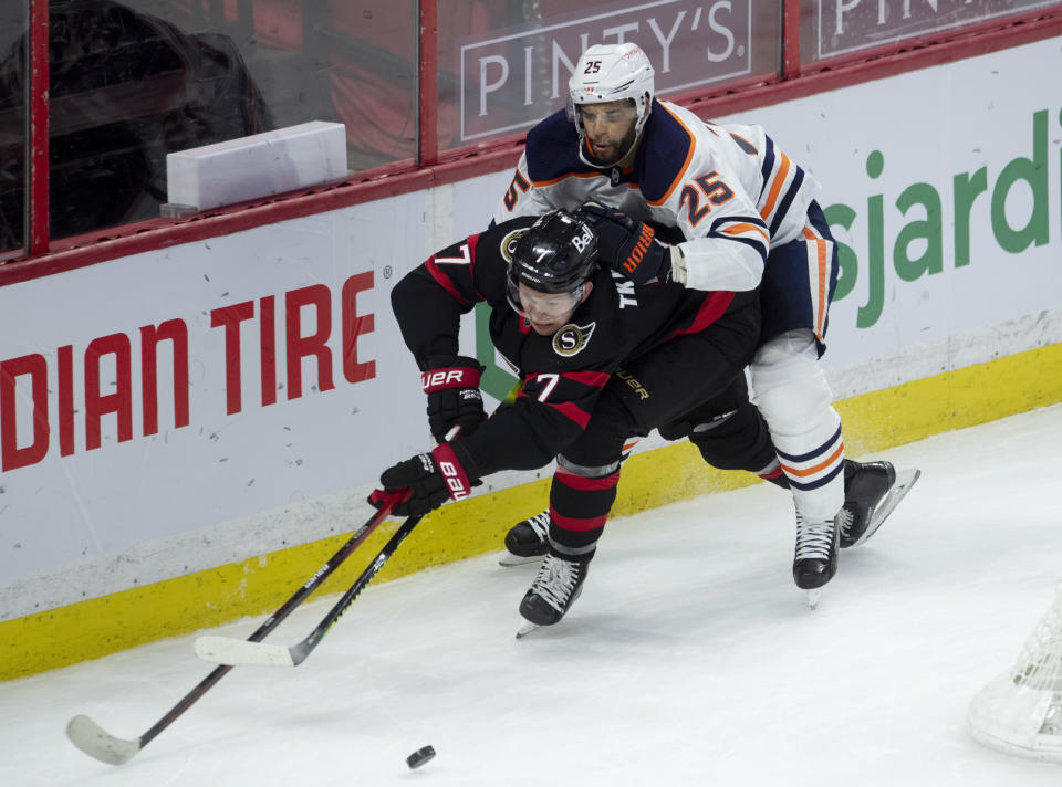 Edmonton Oilers defenseman Darnell Nurse pressures Ottawa Senators left wing Brady Tkachuk as he attempts to pass the puck to the front of the net during the second period of an NHL hockey game Wednesday, April 7, 2021, in Ottawa, Ontario. (Adrian Wyld/The Canadian Press via AP)