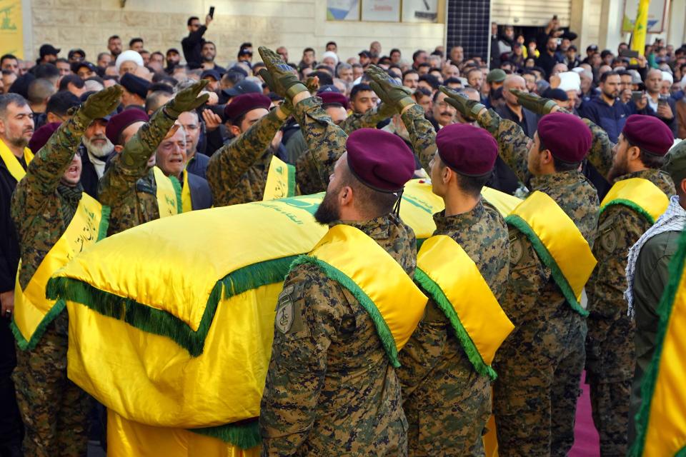 Hezbollah fighters greet as they surrounded the coffin of their comrade, Abbas Mohammed Raad, the son of the head of Hezbollah's parliamentary bloc, Mohammed Raad, who was killed by an Israeli strike, during his funeral procession in the southern town of Jbaa, Lebanon, Thursday, Nov. 23, 2023. The militant Hezbollah group fired more than 50 rockets at military posts in northern Israel on Thursday, a day after an Israeli airstrike on a home in southern Lebanon killed five of the group's senior fighters. (AP Photo/Bilal Hussein)