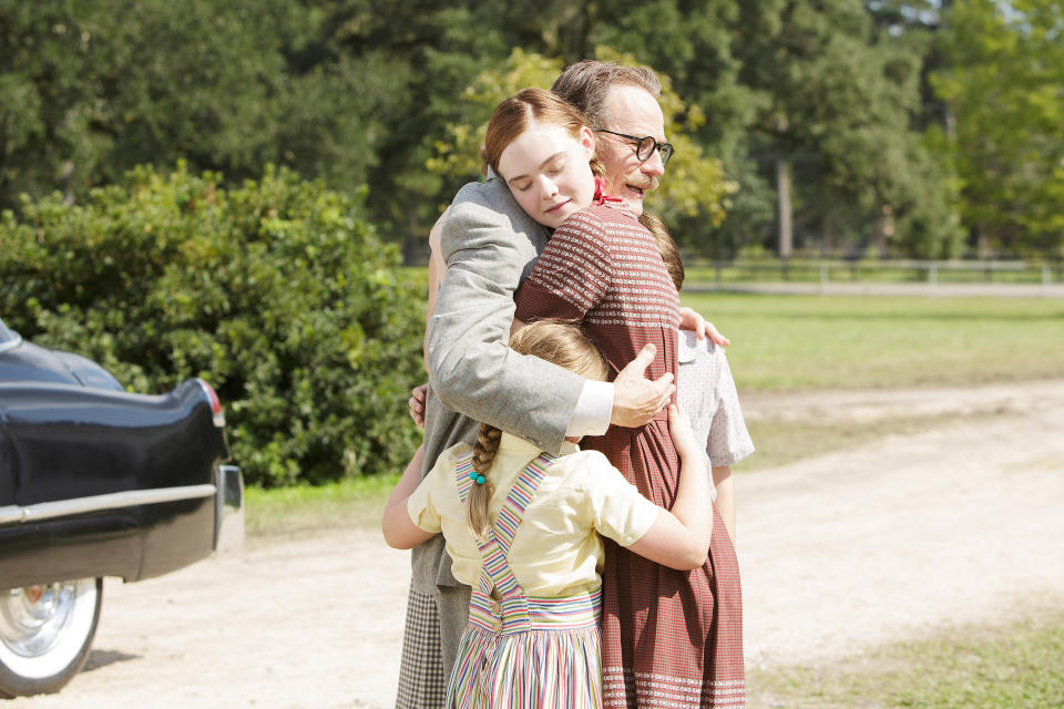 Elle Fanning hugs Bryan Cranston; they are outside